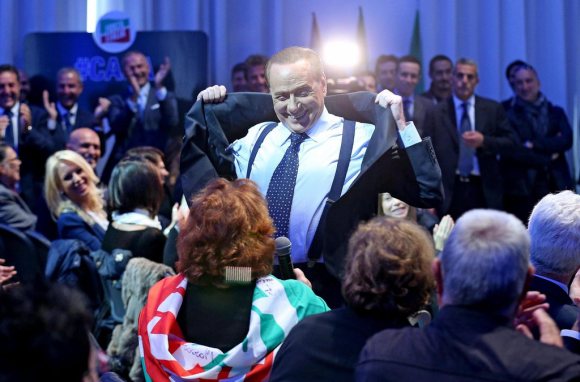 Silvio Berlusconi mostra scherzosamente i pettorali a una Conferenza degli Amministratori locali di Forza Italia