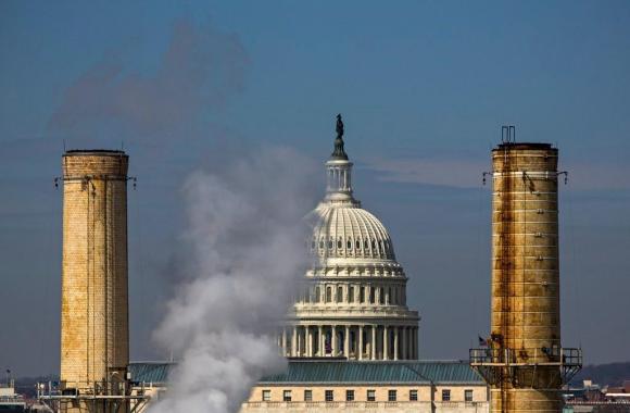 Cupola del Congresso statunitense vista attraverso due ciminiere.