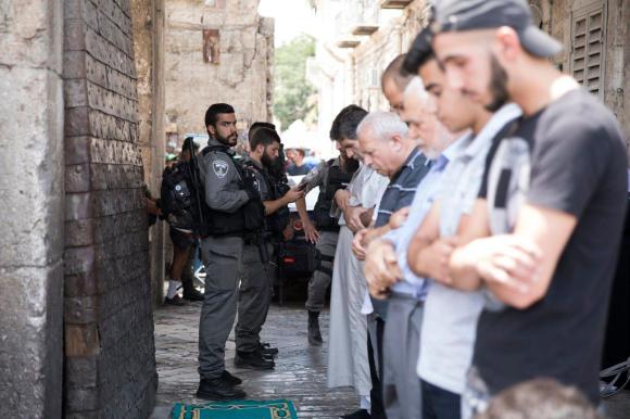 Guardie di confine israeliane e fedeli musulmani alla Porta dei Leoni della Spianata delle Moschee.