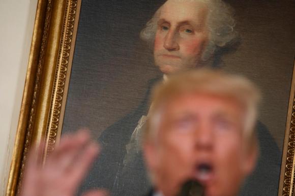 donald trump con alle spalle un ritratto di George Washington