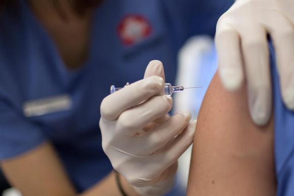 Una dottoressa sta effettuando una vaccinazione a un paziente