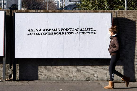 Manifesto con la scritta in inglese: Quando un uomo saggio prende la mira di Aleppo... il resto del mondo guarda il dito