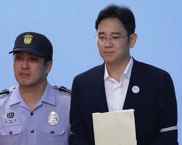 Il vicepresidente della multinazionale Samsung con a fianco un poliziotto