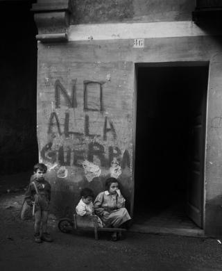 Genova, 1946, scritta sul muro no alla guerra, con in primo piano due bambini