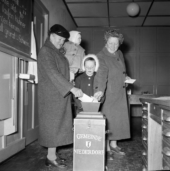 Gente mentre infila la scheda elettorale nell urna