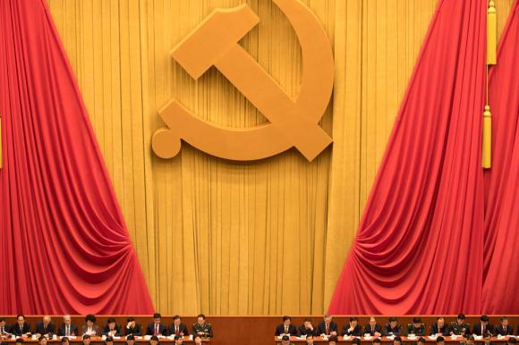 delegati del partito comunista cinese sotto un enorme falce e martello