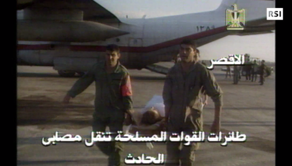 due uomini trasportano su una barella un ferito dell attentato di luxor del 1997