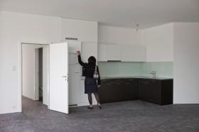 una donna controlla la cucina di un appartamento nuovo