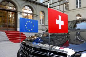 A car sports the flags of the EU and Switzerland