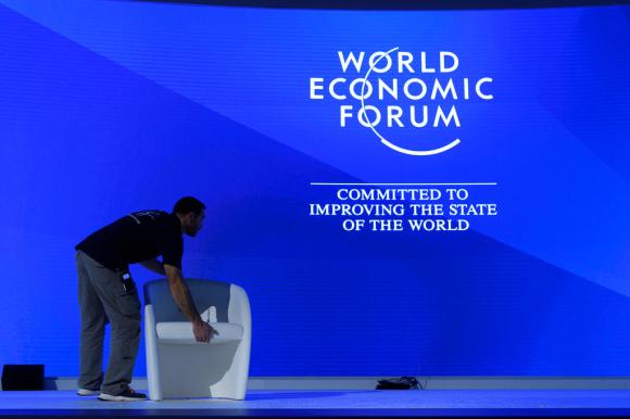 un uomo sta installando una poltrona sul palcoscenico del Forum economico mondiale di Davos.
