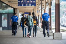 Due guardie di confine interrompono il viaggio di tre migranti alla stazione ferroviaria di Chiasso.