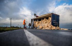 Camion con telone divelto dal vento e contenuto (cassette di legno) riversato su una strada del Nord Reno-Westfalia