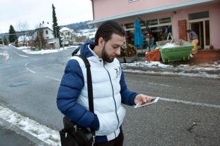 un uomo sta guardano il suo telefono mentre cammina per strada