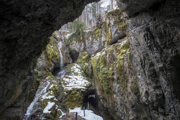 Anfratto tra le rocce ed entrata di una grotta con la scritta Hölloch
