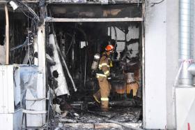 Immagine di locali completamente bruciati, con un pompiere dotato di maschera e bombola di ossigeno in azione