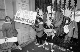 due donne tengono un cartellone in cui condannano i borghesi