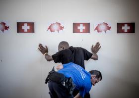 un poliziotto mentre perquisisce una persona di colore