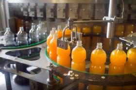 Impianto di imbottigliamento nel quale vi sono bottiglie di aranciata.