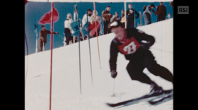 Dai filmati inediti di St. Moritz 48, uno sciatore affronta uno slalom (in primo piano), pubblico (sullo sfondo)