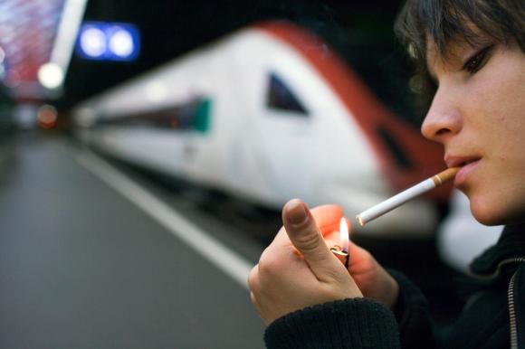 Una ragazza si sta accendendo una sigaretta.