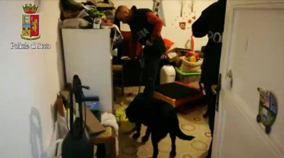 Agenti di polizia accompagnati da cani entrano in un appartamento