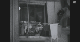 Balcone con panni stessi e materiale vario depositato fuori dalla porta finestra