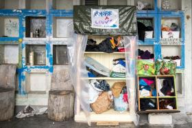 Un armadio e alcuni scaffali installati nei pressi di un autosilo, con coperte liberamente utilizzabili dai senzatetto