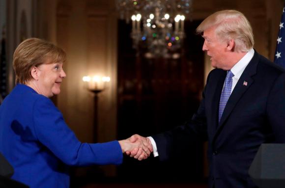 Trump e Merkel si stringono la mano.
