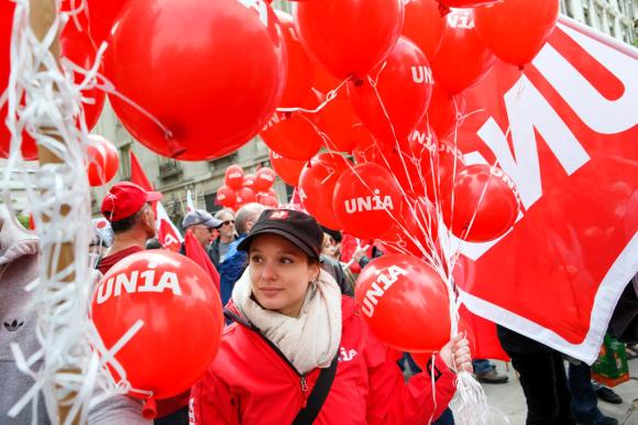 Una ragazza a Ginevra tra palloncini e bandiere rosse mentre partecipa alla tradizionale manifestazione del primo maggio