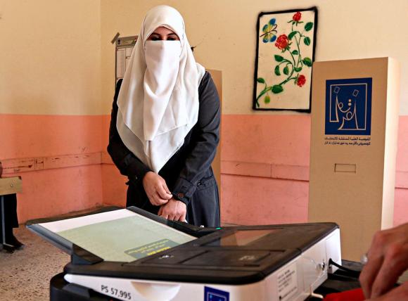 Una elettrice in un seggio di Baghdad
