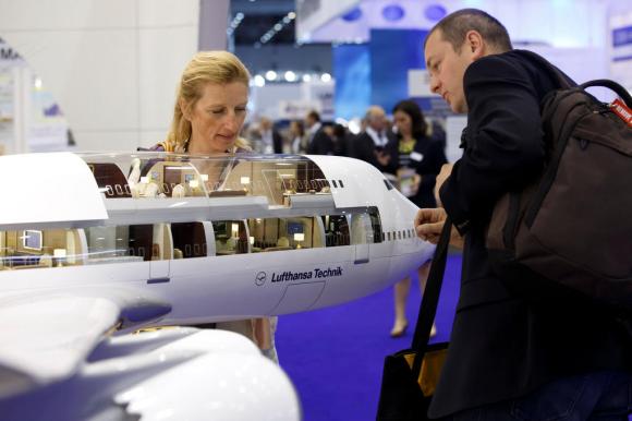 Visitatori di una fiera osservano un modello di jet privato