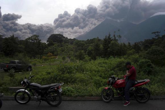 le nuvole di fumo e cenere del vulcano con in primo piano due moto