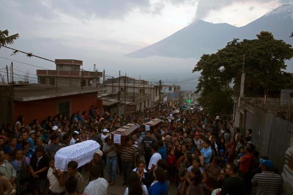 I funerali di alcune vittime dell eruzione con sullo sfondo il vulcano attivo