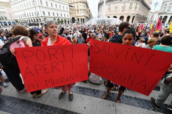 Manifestazione a Genova: una ragazza mostra un cartello con scritto Salvini vergogna e Porti aperti ai migranti