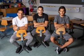 I tre fratelli Rodriguez in posa per il fotografo, seduti su delle sedie di un aula scolastica.