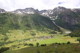 vallata con un villaggio circondato da verdi montagne
