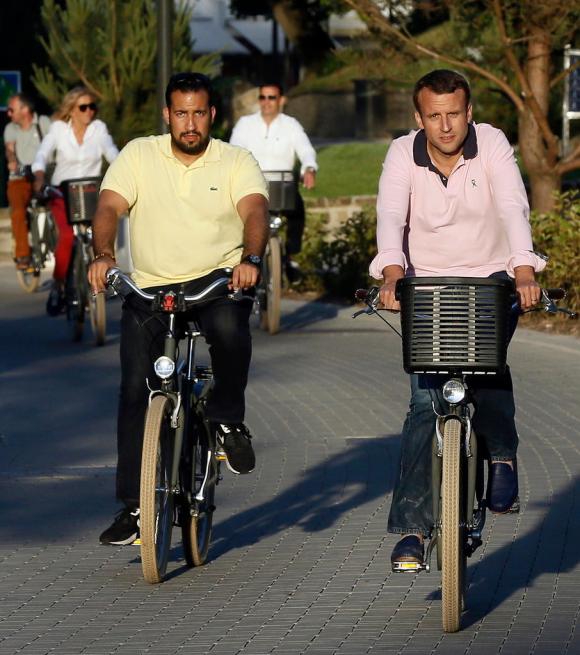 Il presidente francese Macron in bicicletta accompagnato da Benalla