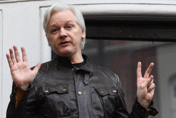 Assange saluta e fa il gesto della vittoria in una foto d archivio