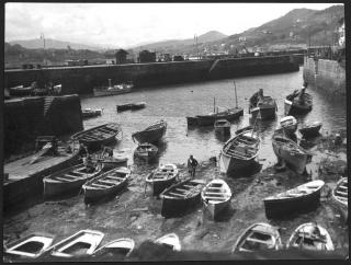 Foto in bianco e nero di un porto con barche durante la bassa marea.
