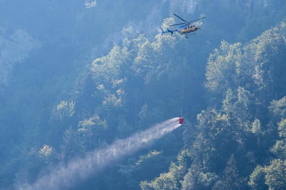 Elicottero dei pompieri in azione per spegnere l incendio provocato dal crash aereo a Hergiswil