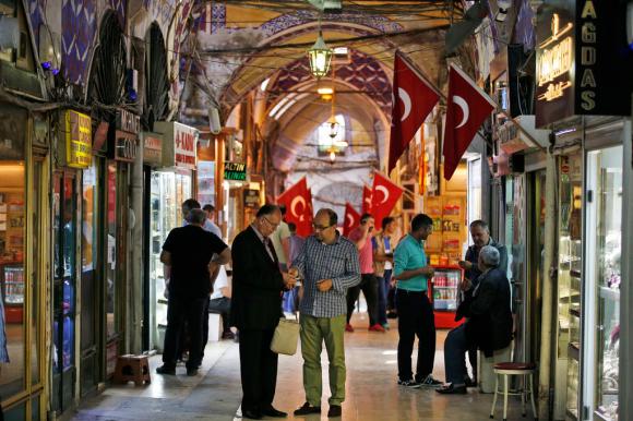 Gente che cambia valuta straniera in un mercato a Istanbul. Si vedono diverse bandiera della Turchia