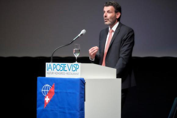 Roberto Balzaretti sul podio, mentre parla, in piedi, davanti al microfono.
