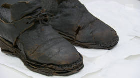 Primo piano di scarponi rovinati dal tempo; dalla foggia si intuisce che appartengono a un altra epoca