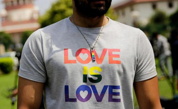Primo piano del busto di un uomo che indossa una maglietta con la scritta Love is love