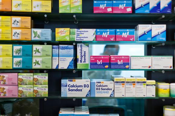 Primo piano di ripiani di farmacia con confezioni di diversi farmaci e prodotti naturali per la salute