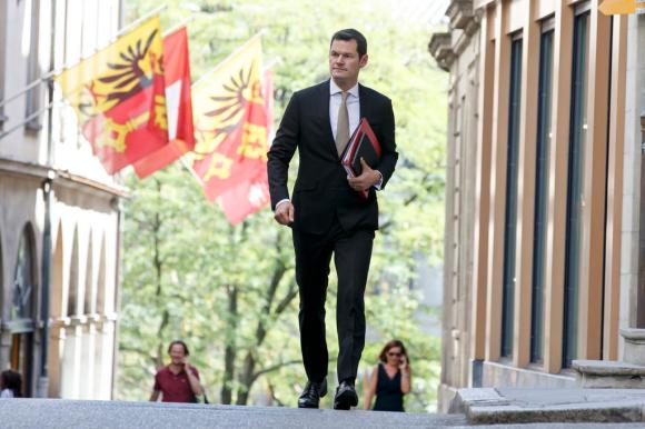 Pierre Maudet in una foto f archivio mentre cammina con dossier in mano nella città vecchia di Ginevra