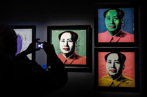 Un visitatore fotografa le serigrafie di Mao tse-tung
