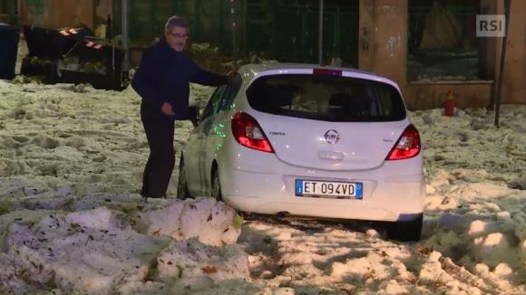 Una macchina bloccata dalla grandine che sembra neve sulle strade di Roma