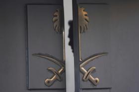 una porta socchiusa con lo stemma dell Arabia saudita