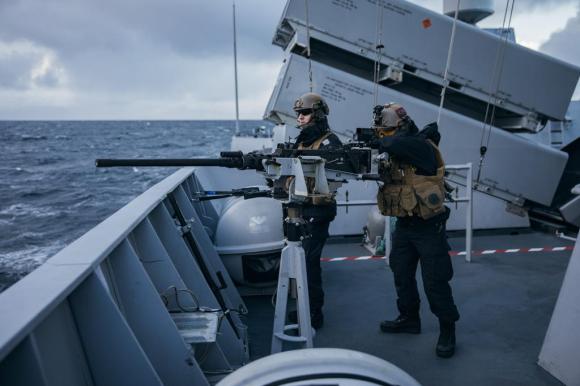 Due soldati posizionati davanti a un mitra su una nave della marina reale norvegese